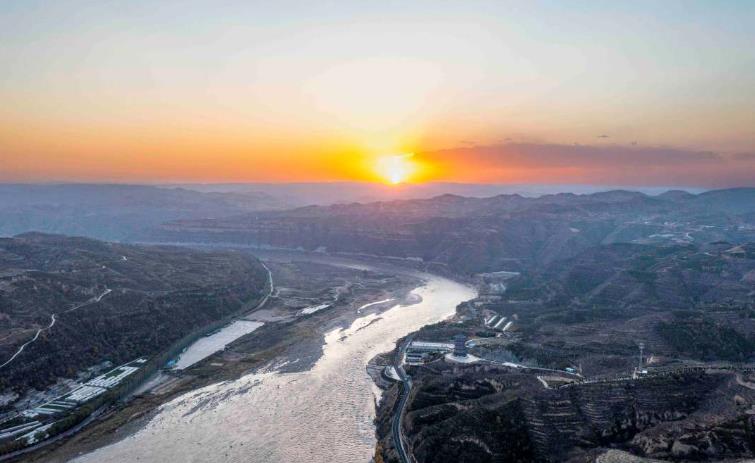 夕陽下的磧口夕陽西下、彩霞滿天，寬廣的黃河水與遠(yuǎn)山形成壯闊斑斕的畫卷。